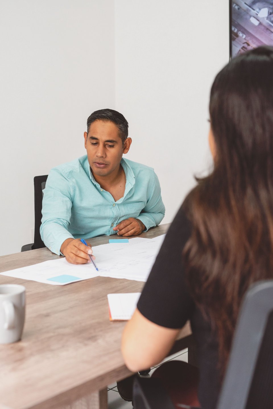 Two professionals discussing a project plan at a desk.