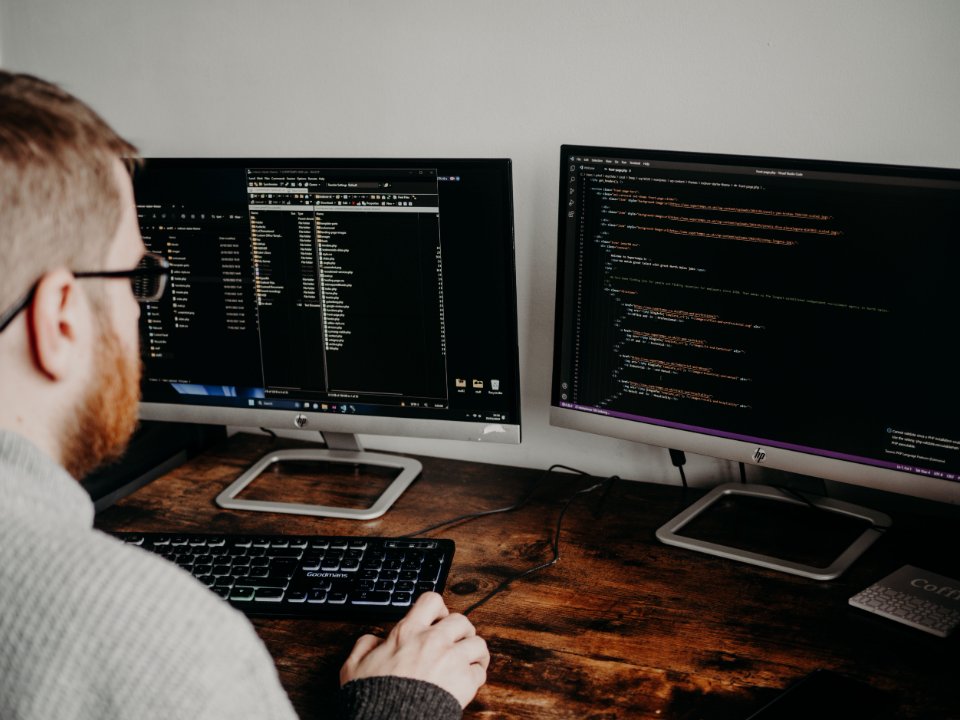 A developer working with source code on two monitors.