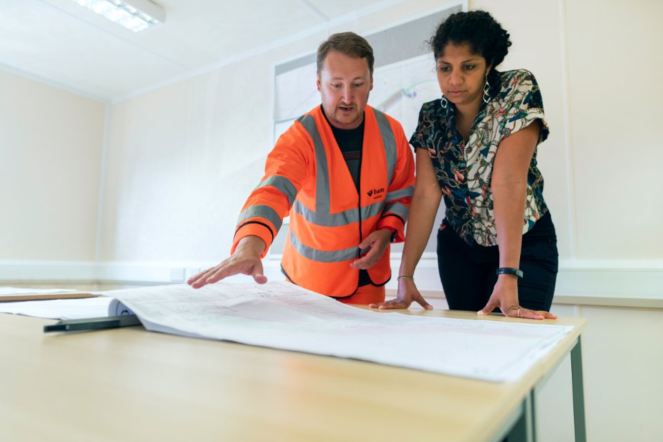 Two engineers reviewing operational plans together at a worktable.