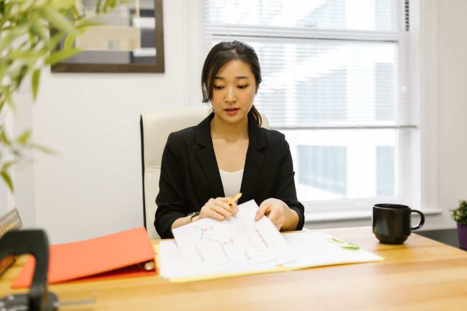 A professional reviewing company documents at an office desk.