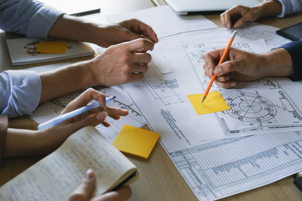 Colleagues examining project drawings and documents together.