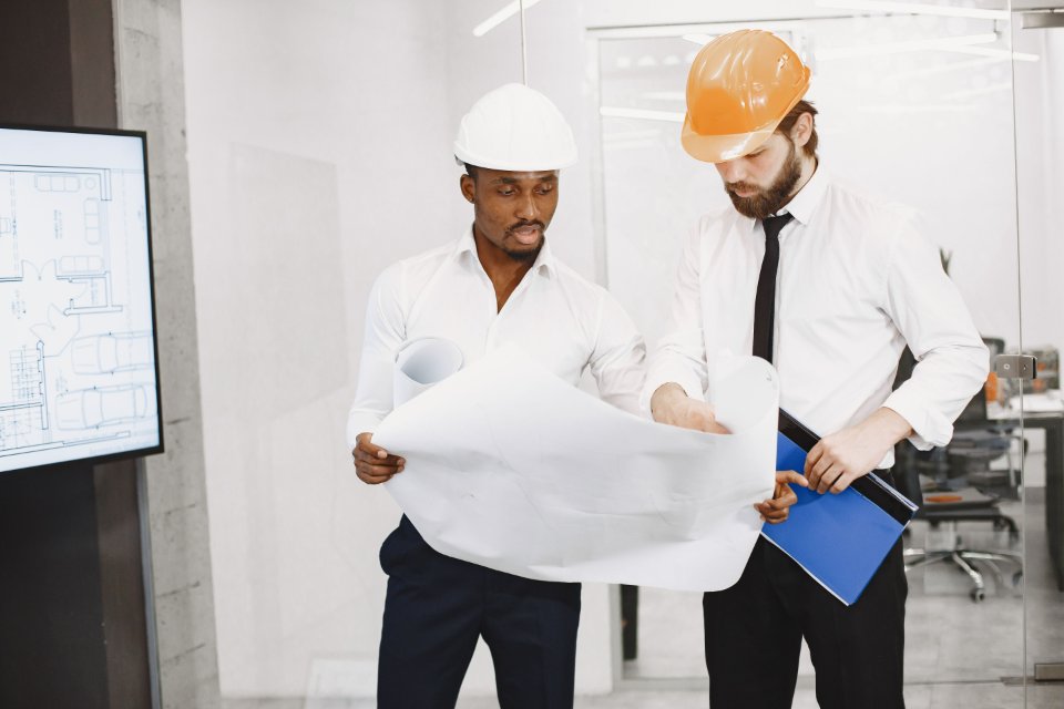 Two engineers reviewing a project blueprint together.
