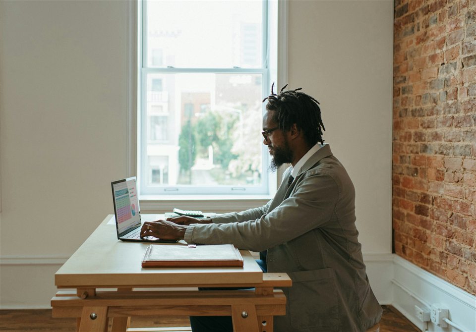 A professional working with a laptop and documents at a desk.