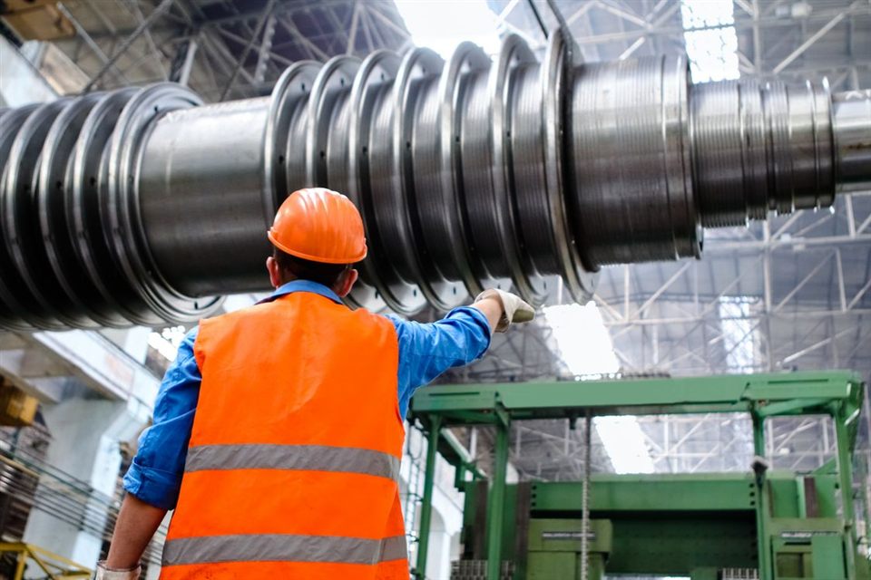 An industrial worker inspecting manufacturing equipment.